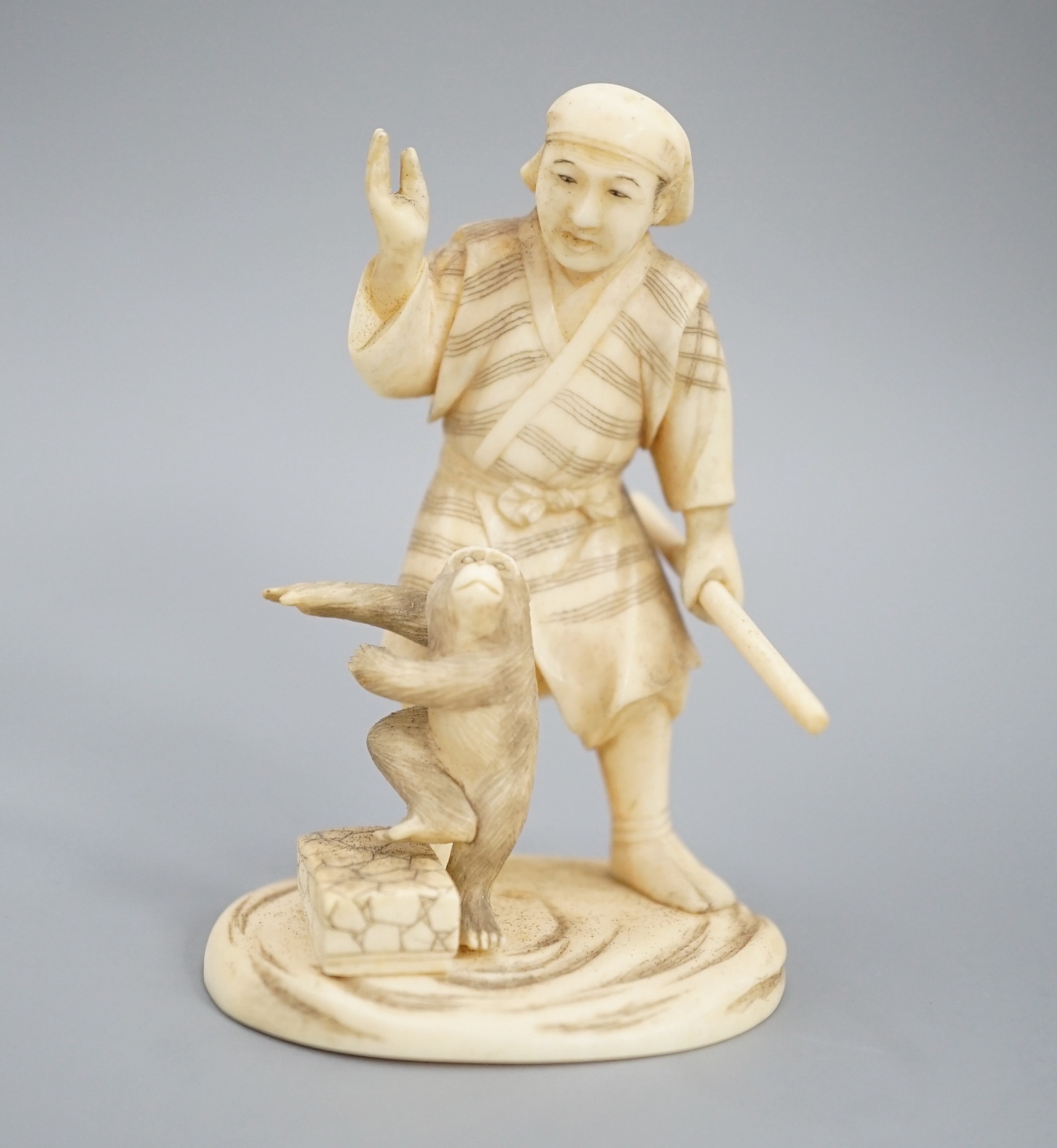A Japanese ivory okimono of a monkey trainer, signed, Meiji period, 7.7 cm
